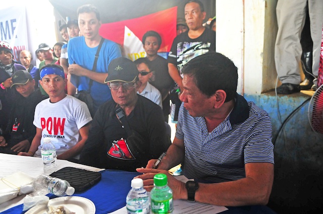 Rodrigo Duterte (right) receives Army Sgt. Adriano Bingil (left, in white shirt) from the New Peoples Army in Barangay Durian, Las Nieves, Agusan del Norte on New Year’s eve, Dec. 31, 2015. Bingil was released after 104 days in captivity. MindaNews photo by Froilan Gallardo