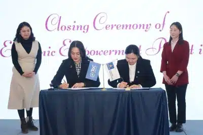 2 women sign MoU with two women standing behind them on respective sides.