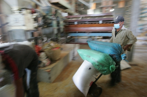 Cambodiaricemill Workers load bags of rice at mill in Cambodia