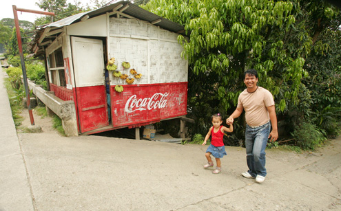 People pass an old Coke sign in the Philippines 