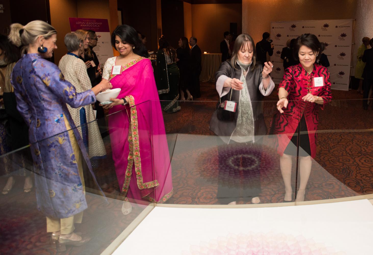 Amy Ovalle, Pratyusha Sibal, Debby Carter and Winnie Feng add Lotus flowers to