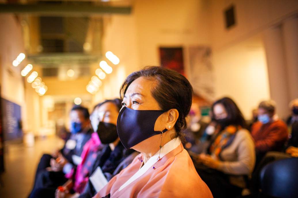 Woman in facemask watches event