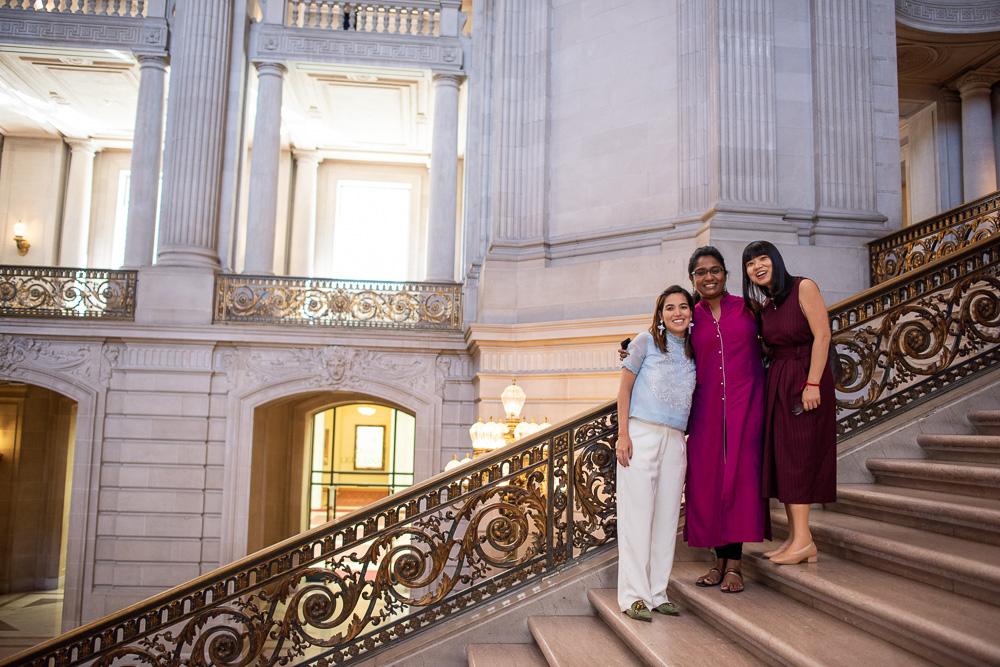 Three female Development Fellows take a photo on stairs