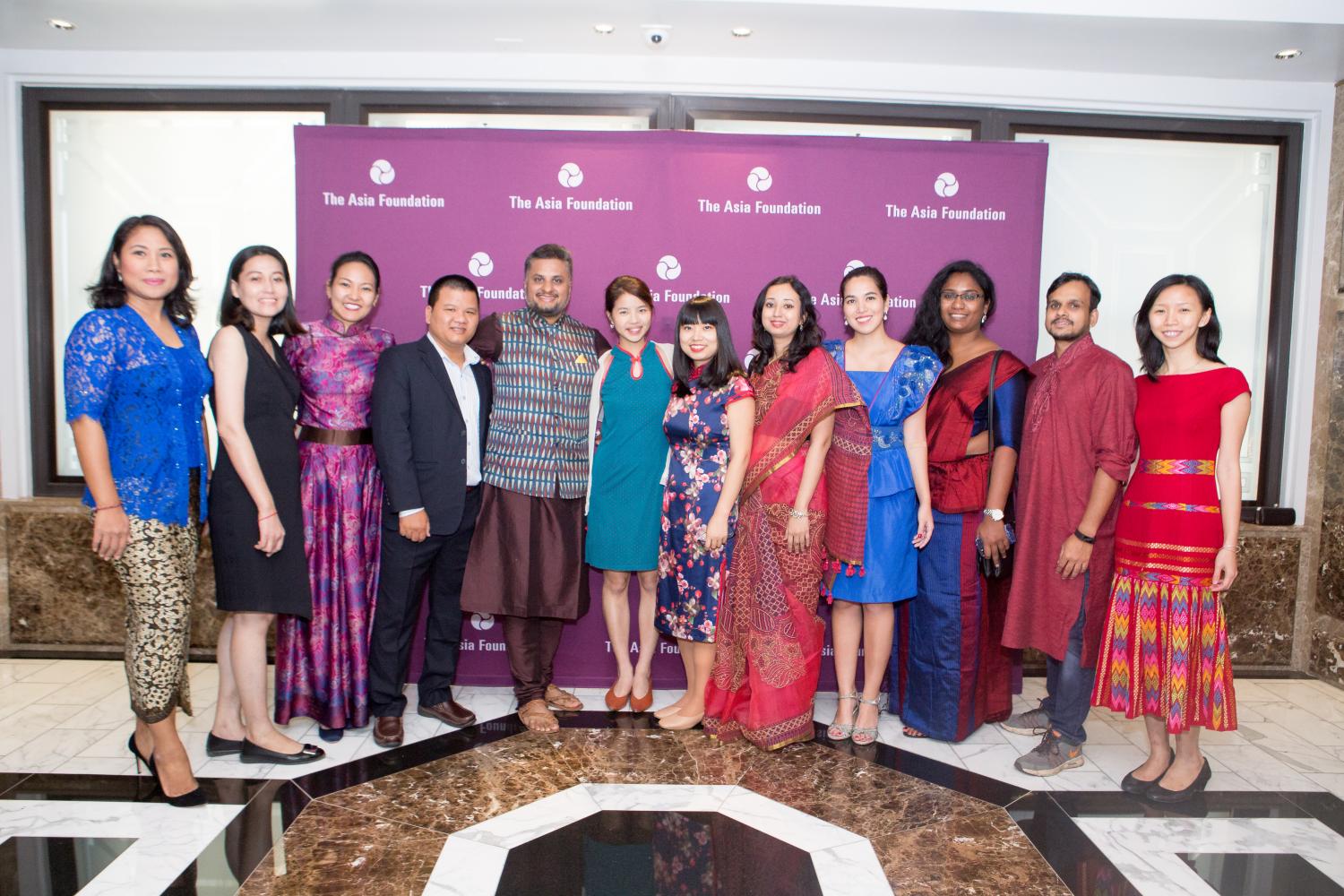 The 2018 Asia Foundation Development Fellows gather for photo in front of step and repeat banner