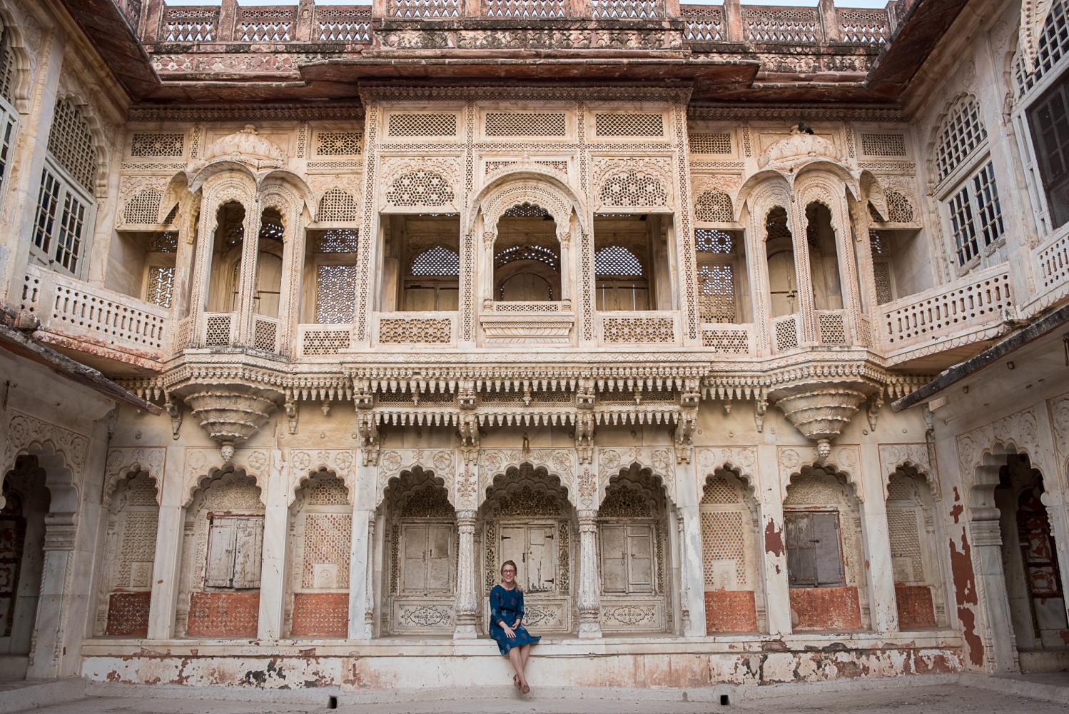 Young woman sits on stoop of old building
