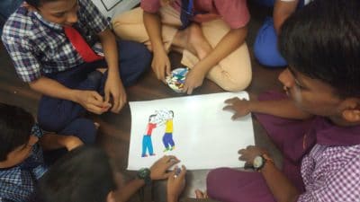 A group of Indian boys surround child's drawing