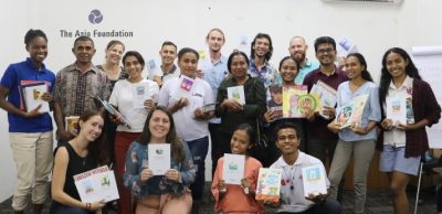 A group of people pose with books
