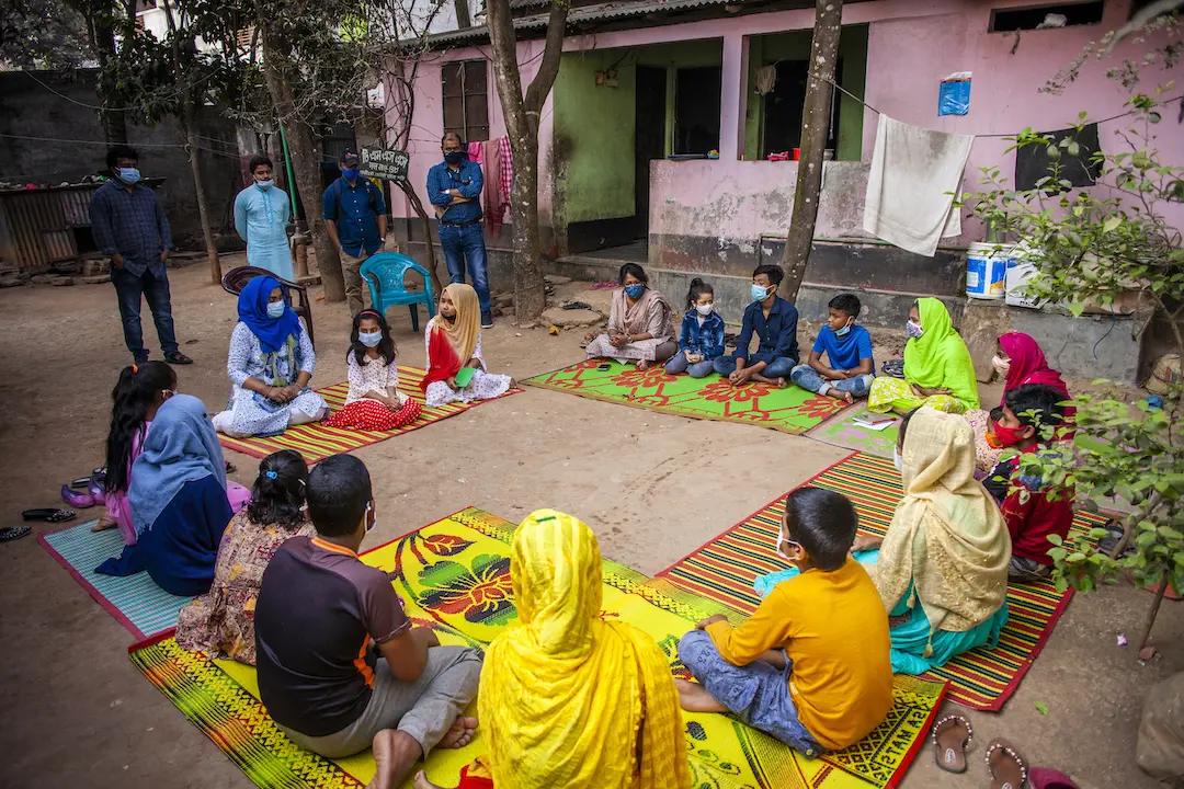 children sit outside in a circle