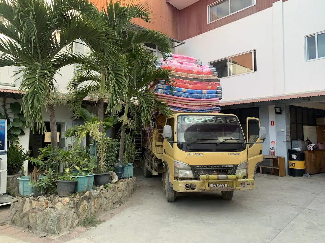 Yellow truck piled with sleeping mats.
