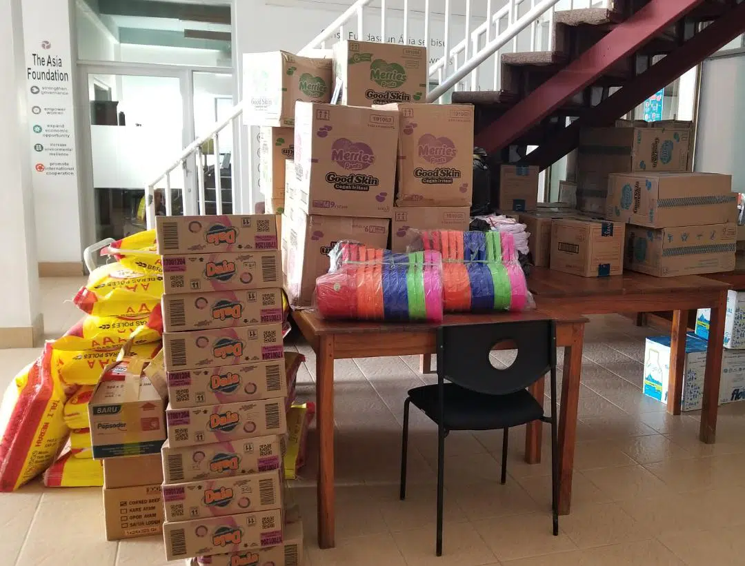 Boxes of donated items on a wooden table.