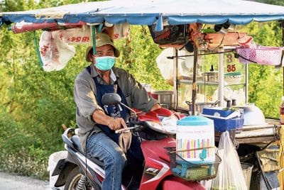 Masked vendor moves his motorized shop cart