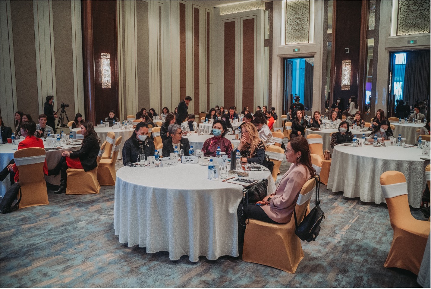 audience members sit at round tables