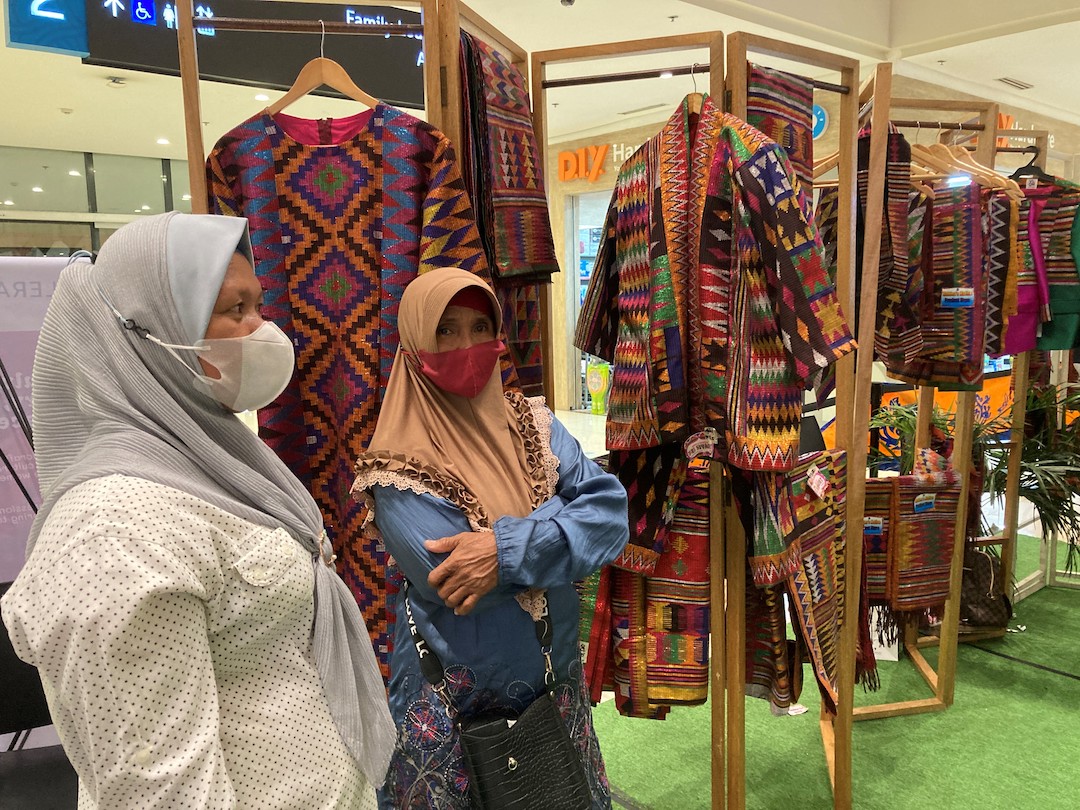 Two women stand in front of their exhibition