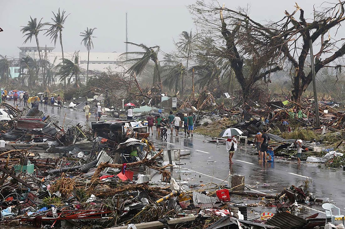 Residents walk on a road littered with debris after Super Typhoon Haiyan battered Tacloban city in central Philippines.