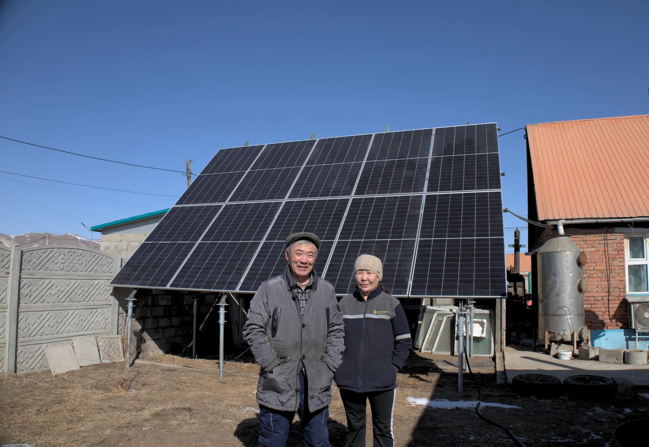 Mr.Namsraidorj and Ms.Davaakhuu in front of their detached house and 10kW solar panels
