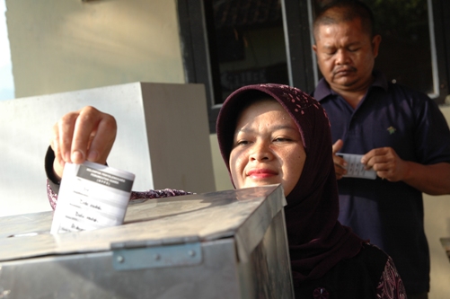 Voter cast ballot in Indonesia's local elections.
