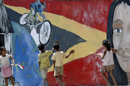 Children Playing in Front of Mural Promoting Tour-de-Timor Cycle Race