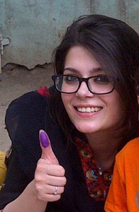 A young Pakistani voter displays the distinct ink-mark that signifies she voted. 